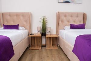 新帕扎尔Motel KVELE的紫色枕头间内的两张床