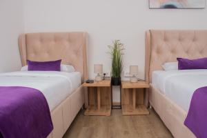 新帕扎尔Motel KVELE的紫色枕头间内的两张床