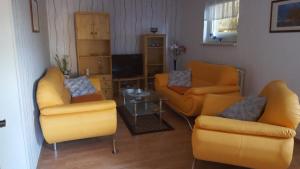 克吕茨Mühlenblick的客厅配有黄色椅子和桌子