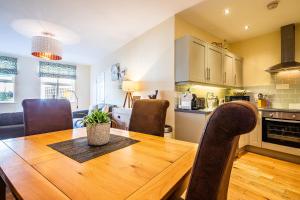 巴克斯顿Buxton centre cosy cottage with free secure parking的厨房以及带木桌和椅子的用餐室。