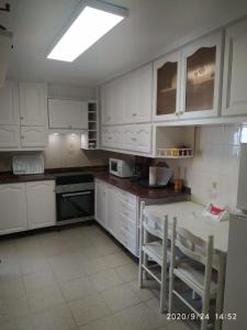 圣波拉Apartamento 3hab的厨房配有白色橱柜和桌椅
