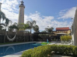 卡塔尼亚西亚拉比斯卡里住宿加早餐旅馆的一座灯塔,位于一座带灯塔的游泳池旁