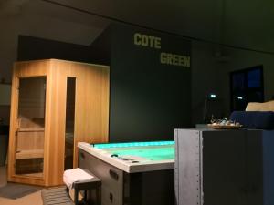 Combles-en-BarroisGite - COTE GREEN的绿色墙壁的房间内的热水浴缸