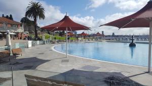 吉朗Gateway to the Surf Coast and Geelong的度假村内带遮阳伞的大型游泳池