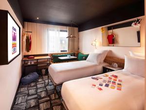 伦敦Mama Shelter London - Shoreditch的酒店客房,设有两张床和一张沙发
