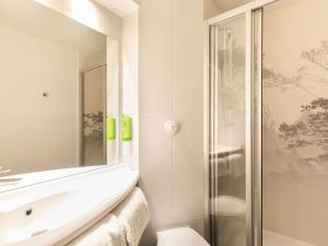 博讷greet Hotel Beaune的白色的浴室设有水槽和淋浴。