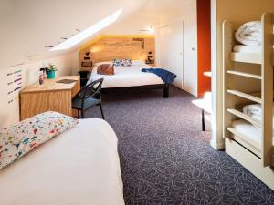 博讷greet Hotel Beaune的酒店客房配有两张床和一张书桌