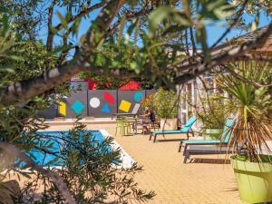 维特罗勒greet Hotel Marseille Provence Aéroport的一个带游泳池、椅子和植物的度假胜地