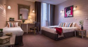 安锡阿尔卑斯酒店的酒店客房设有两张床和一张桌子。