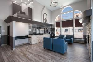 米德瓦尔Quality Inn Midvale - Salt Lake City South的一间带2把蓝色椅子的客厅和一间厨房