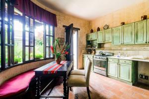 危地马拉安地瓜Casa Serenidad的厨房配有绿色橱柜和桌椅