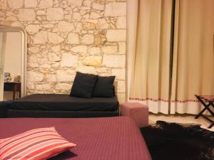 锡拉库扎艾桑提克罗那提酒店的带沙发和石墙的客厅
