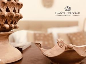 锡拉库扎艾桑提克罗那提酒店的木碗坐在花瓶旁边的桌子上