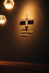 轻井泽HOTEL KARUIZAWA CROSS的墙上的标志,上面有十字架