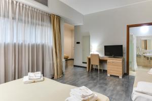 罗马Garden Area Roma Eur的酒店客房设有两张床和一张书桌及电视