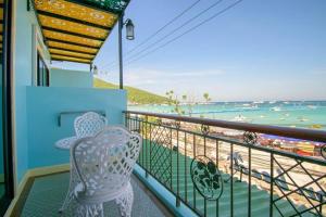 格兰岛TC villa on beach的阳台配有两把椅子,享有海滩美景