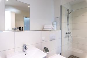 卡尔本Luxstay Karben Neue Mitte - Self-Check-In的白色的浴室设有水槽和淋浴。