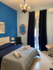 马奥莱Casa Cristina的一间蓝色卧室,配有一张床和一个吊灯