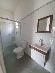 林多亚Suítes Laure的白色的浴室设有卫生间和水槽。