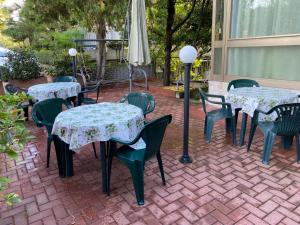 廖洛泰尔梅弗兰卡酒店的庭院里摆放着几张桌子和椅子,上面摆放着鲜花
