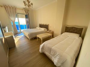 都拉斯Hotel 3 Vellezerit的酒店客房设有两张床和窗户。