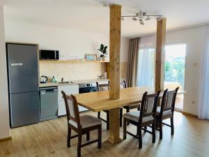 埃格尔Egria Apartments的厨房以及带木桌和椅子的用餐室。