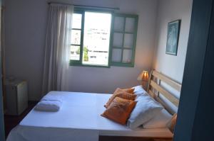 萨尔瓦多Pousada Baluarte的卧室配有白色的床和窗户