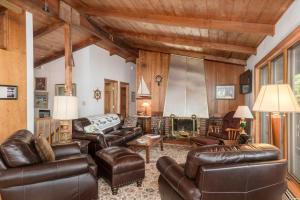 MoultonboroughLake Winni - WF - 383的客厅设有皮革家具和木制天花板。