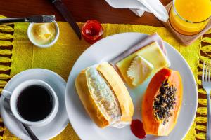 安格拉杜斯雷斯Pousada e Restaurante Mangue Seco Angra的盘子,上面有两块三明治和一杯咖啡