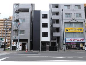 札幌Uchi Living Stay AOZORA的一条空的城市街道,两座高楼