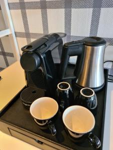 厄伊特霍伦Amsterdam Hotel Uithoorn的咖啡壶,带两个杯子