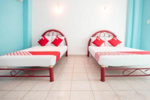 José CardelOYO Hotel Estacion,José Cardel,Parque Central Revolución的配有红色和白色枕头的客房内的两张床