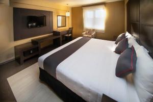 乔卢拉Collection O Las Iglesias, Cholula的酒店客房设有一张大床和一台电视。