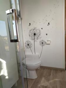 ChampdrayChalet du Spièmont的浴室设有卫生间,墙上挂有蒲团和蝴蝶