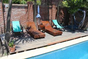 马德普拉塔Habitación en villa neo victoriana con piscina的一个带椅子的木制甲板和游泳池