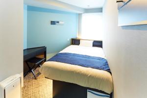 东京ICI HOTEL Tokyo Hatchobori的一间小卧室,配有一张床和一张书桌