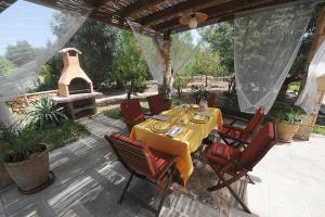 莱乌卡Villa Serena Maria的庭院配有桌椅和壁炉。