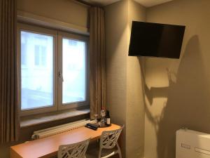 科特赖克Hotel Duivels Paterke Harelbeeksestraat 29, 8500 Kortrijk的酒店客房设有桌子和窗户。