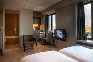根特Castelnou Aparthotel的酒店客房设有电视和浴室。