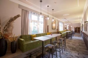 埃森Hotel Essener Hof; Sure Hotel Collection by Best Western的餐厅设有绿色的沙发和桌椅