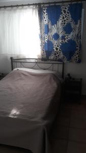 阿特米达Nina Rooms (apartments)的一间卧室配有床和带窗帘的窗户