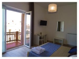 加利波利Faro Bianco Gallipoli Dependance的一间卧室设有一张床和一个大型滑动玻璃门