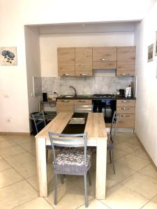 卡洛福泰Casa Francesca的厨房配有木桌和椅子