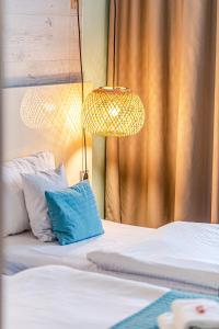 罗兹NoBo Hotel - business的客房设有两张带灯和蓝色枕头的床。