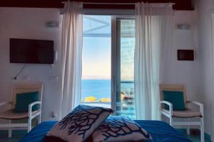 伊斯基亚Dependance Castiglione with pool and view的一间卧室配有一张床,享有海景