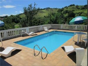 林多亚林多亚乡村酒店的一个带椅子和遮阳伞的大型游泳池