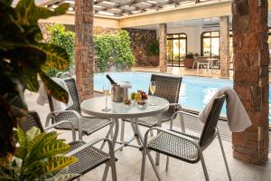 格拉玛多Serrazul Hotel Distributed By Intercity的游泳池旁带桌椅的天井
