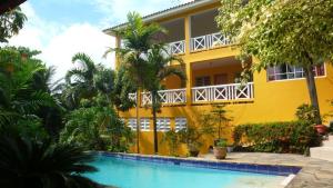圣斐利-银港卡萨热带酒店的黄色的房子,前面有一个游泳池