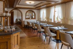 Rehau法兰克之家酒店的用餐室配有长桌子和椅子