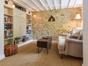 奇平诺顿Browns Cottage的带沙发和砖墙的客厅